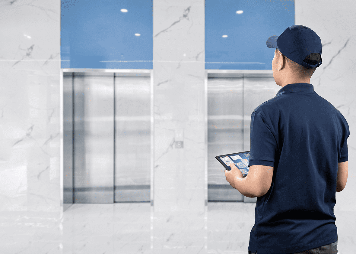 Person with tablet facing two elevators.