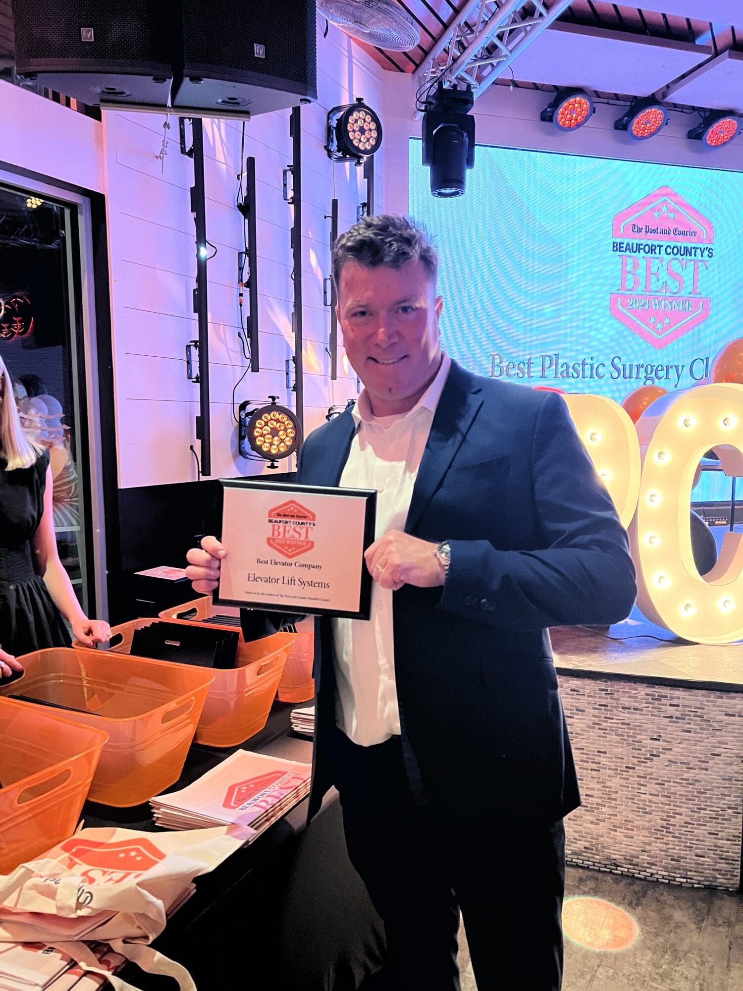 Man holding award at indoor event.