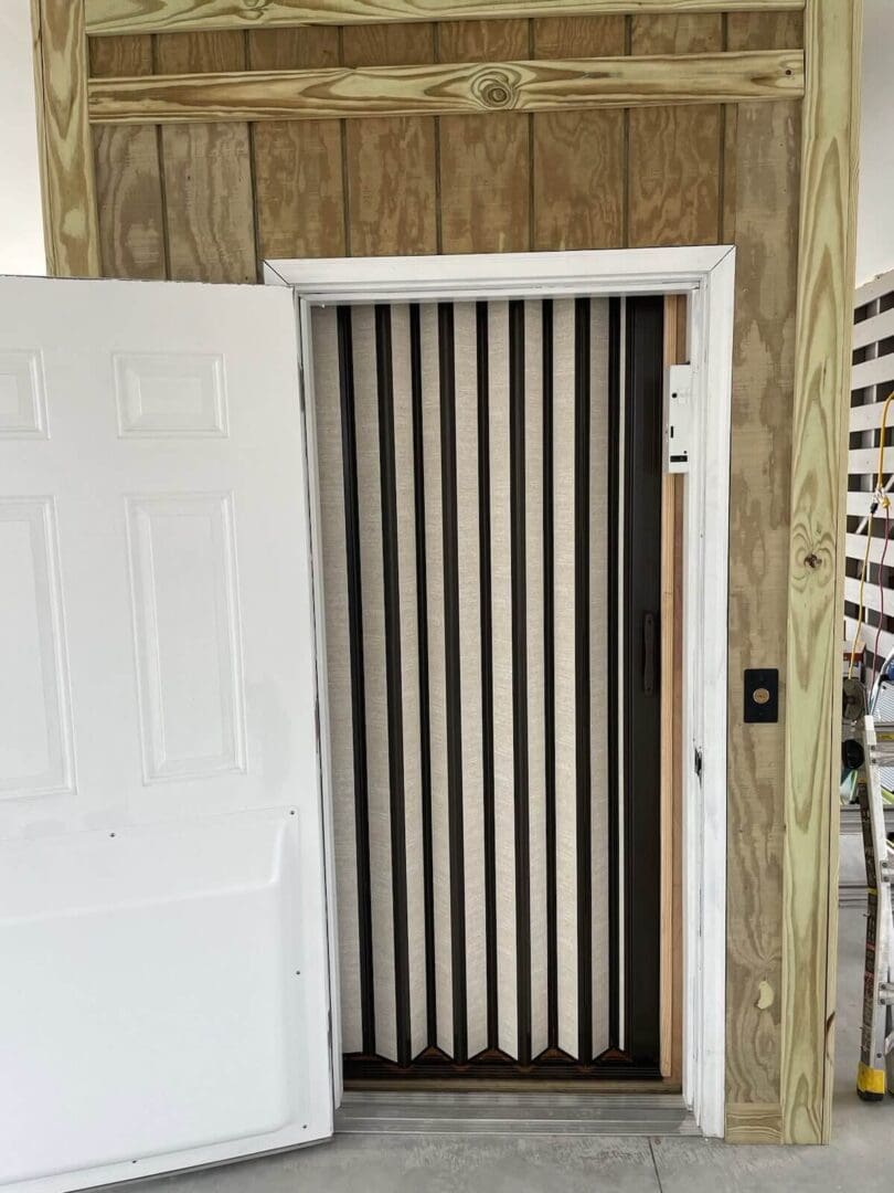 White door with striped accordion-style curtain.