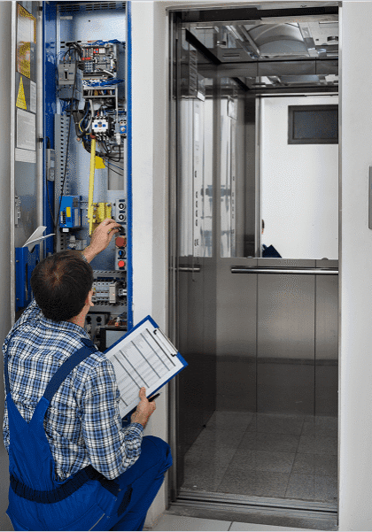 Technician inspecting elevator control panel.