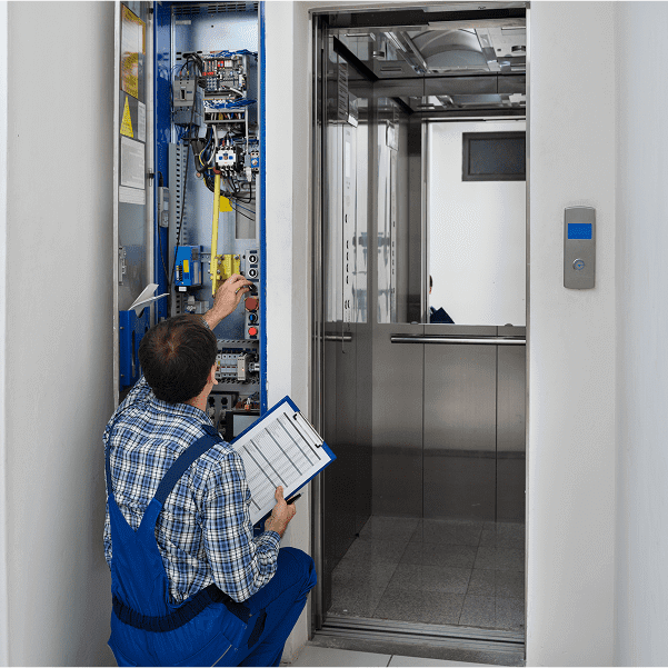 Technician inspecting elevator control panel.